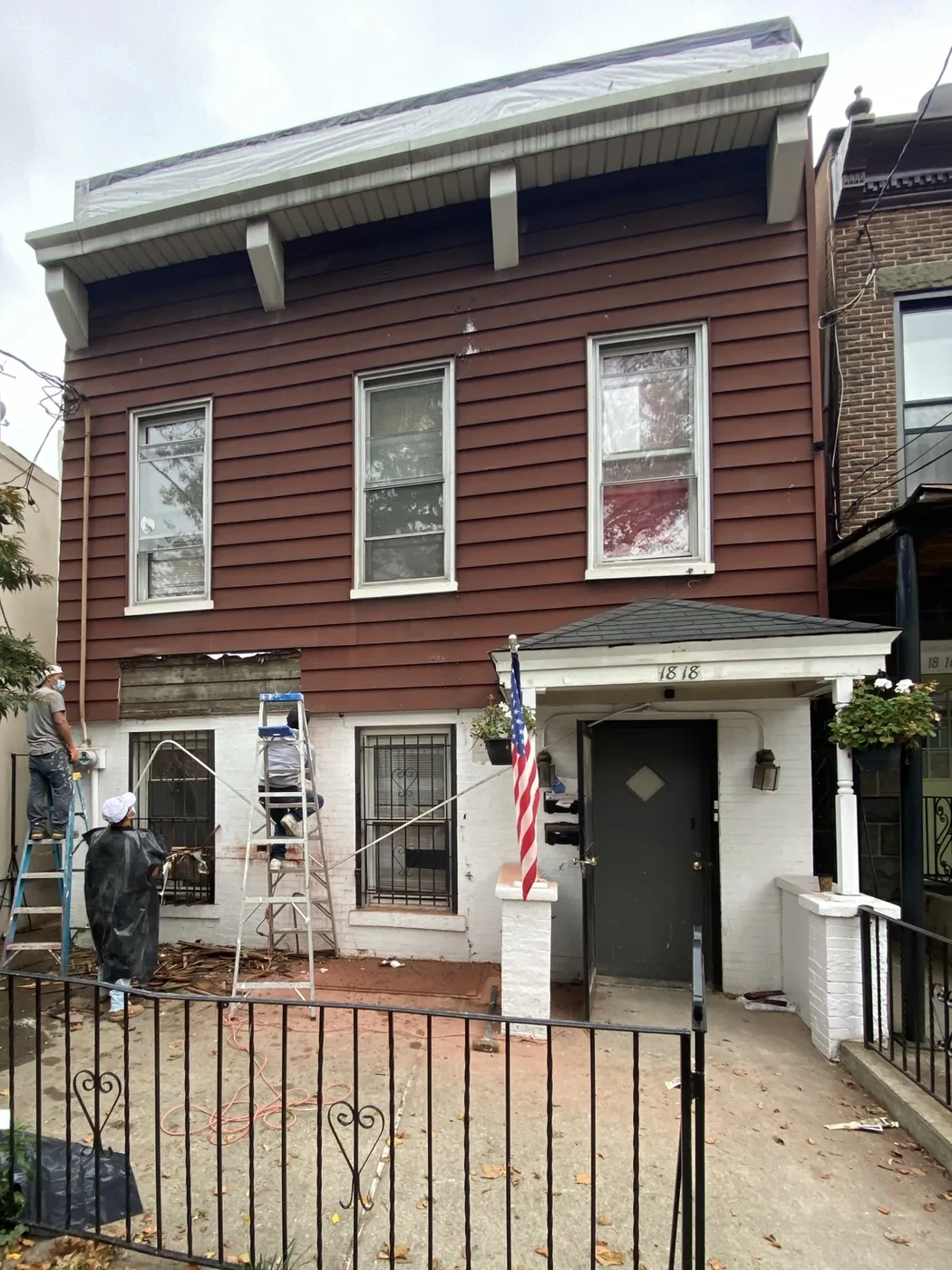 1818 25th Road Astoria before renovation — two-story house with dark red siding and a small entry portico
