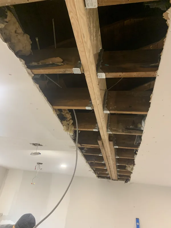 The recessed structural beam opening at the ceiling where the dividing wall was removed in the Bayside kitchen, framed flush with hangers and ties