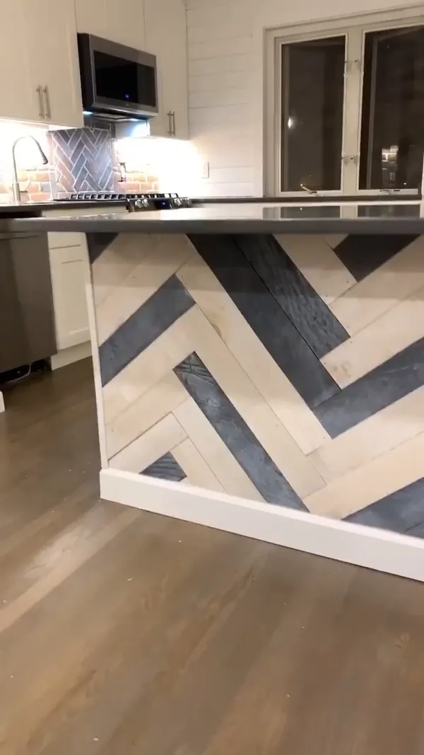 Detail of the two-tone herringbone island cladding with white baseboard trim