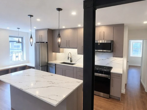 The Bayside kitchen and living area now reading as one connected space, with pendants over the island