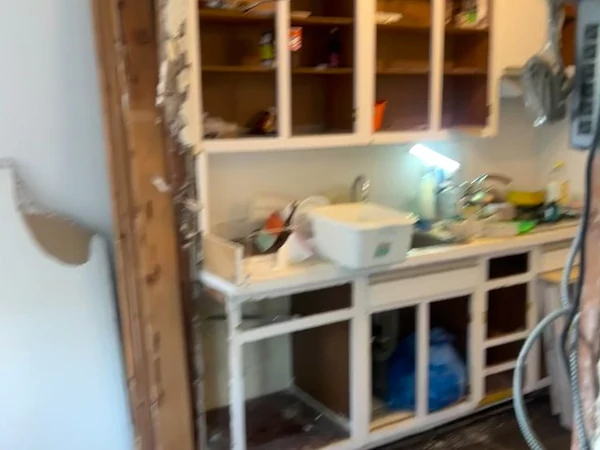 Limited open painted shelving along the run of the old kitchen that would later become the new full-height cabinetry wall