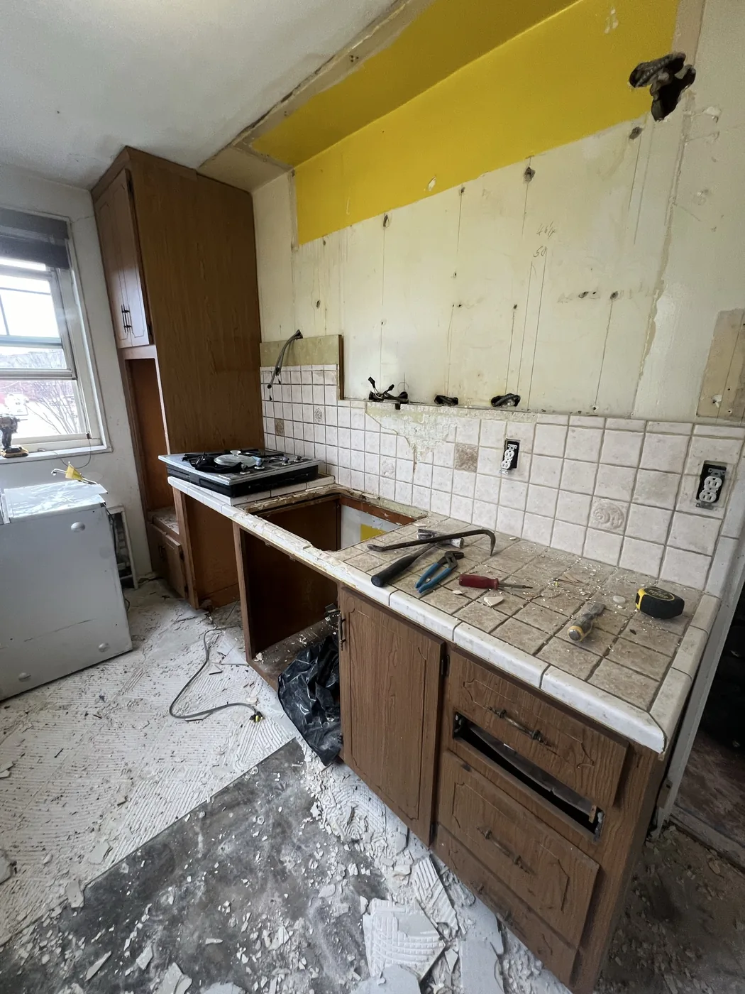 Douglaston kitchen before renovation, oak cabinets, tile countertops and a yellow painted soffit