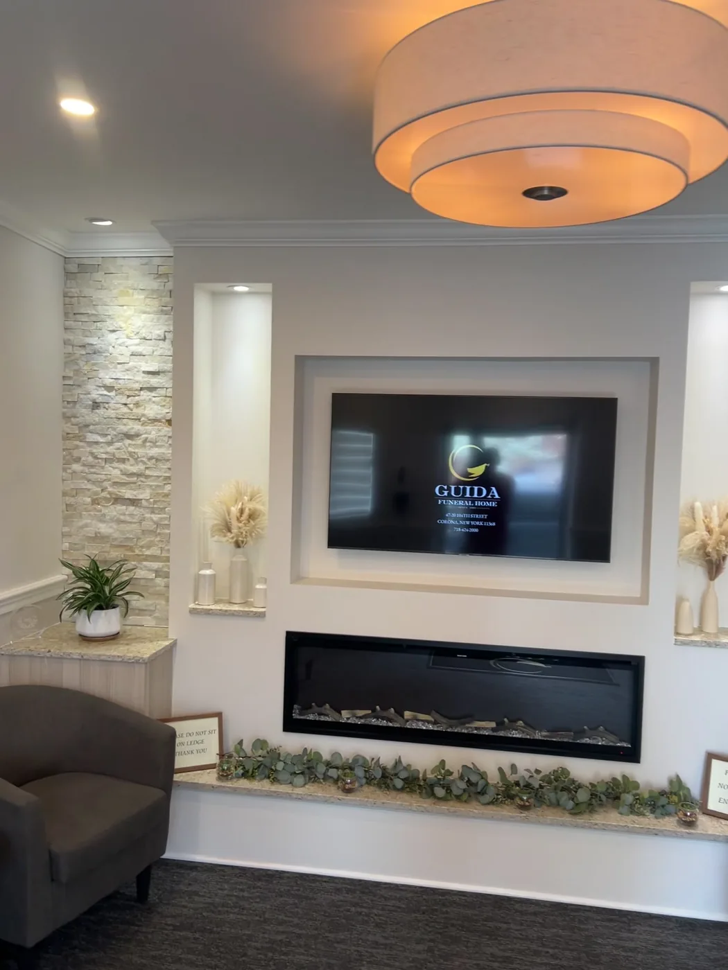 Guida Funeral Home memorial wall finished — stacked stone, linear fireplace and recessed tribute display