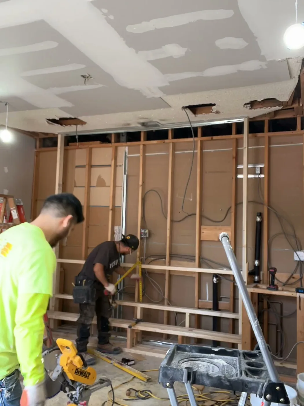 Guida Funeral Home memorial wall during construction — timber framing with openings set out for display and fireplace