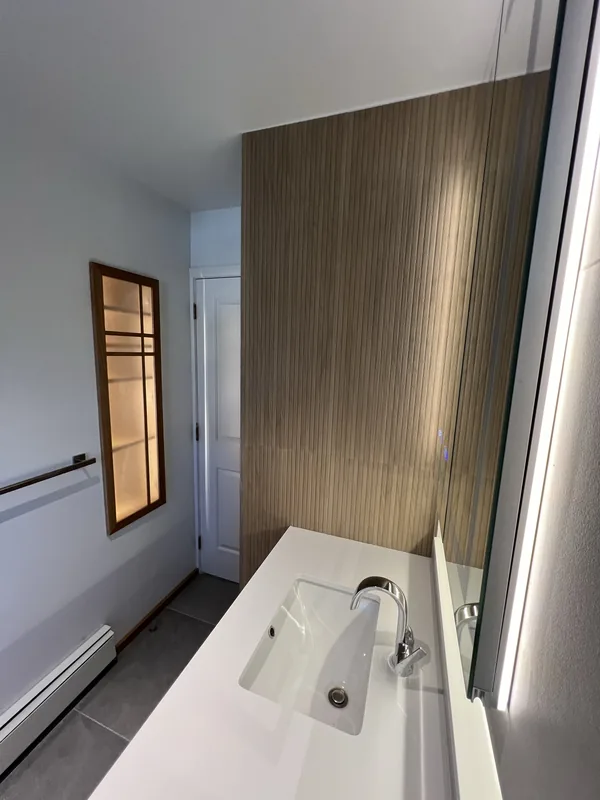 The custom shoji screen window cover installed over the shower window in the finished Great Neck bathroom