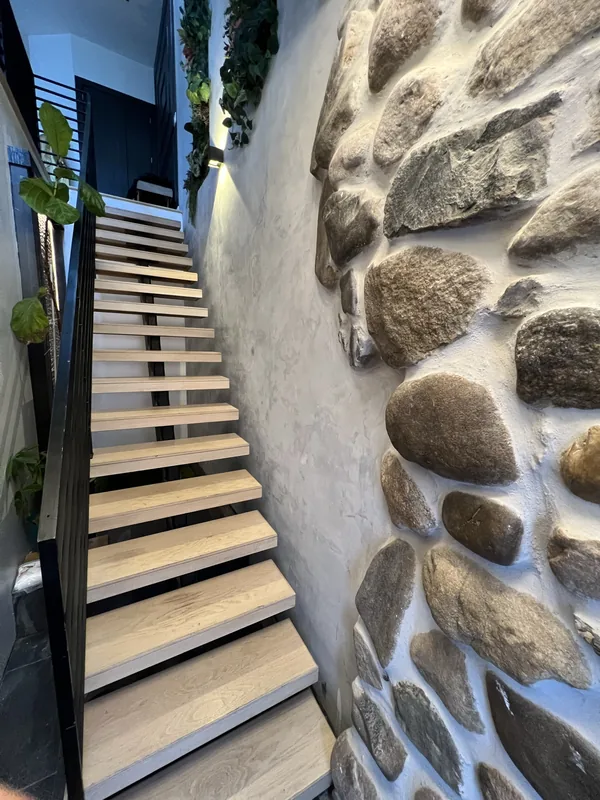 Looking up the stair from the entry level, past the natural river-stone wall.