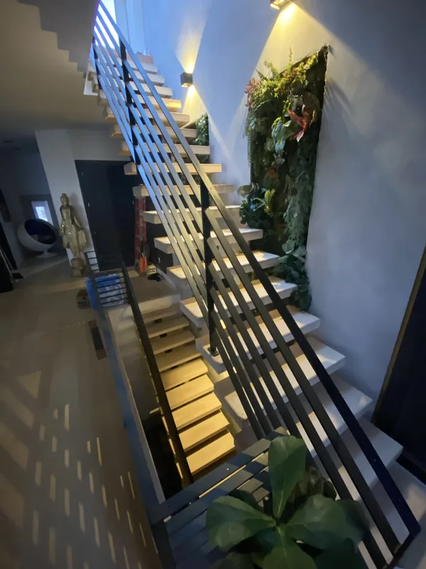 Close view of the black railing lines and step lighting at night.
