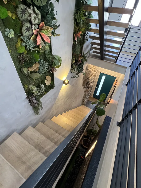 Top-down view of the stairwell, treads and botanical wall.