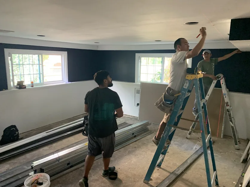 The Malba family room at the rough-in stage, with framing, ladders and rough materials in the room.