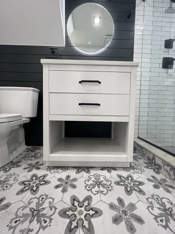 Vanity from the front with the grey-and-white patterned hex floor tile.