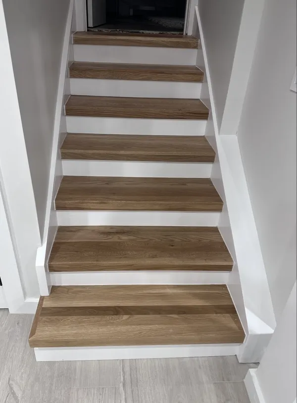 New basement staircase with white-oak treads and white risers.