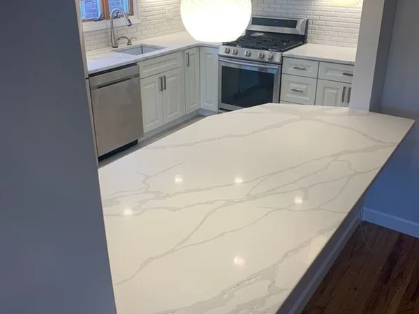 After: L-shaped kitchen run with gas range, chimney hood, dishwasher and sink under the window
