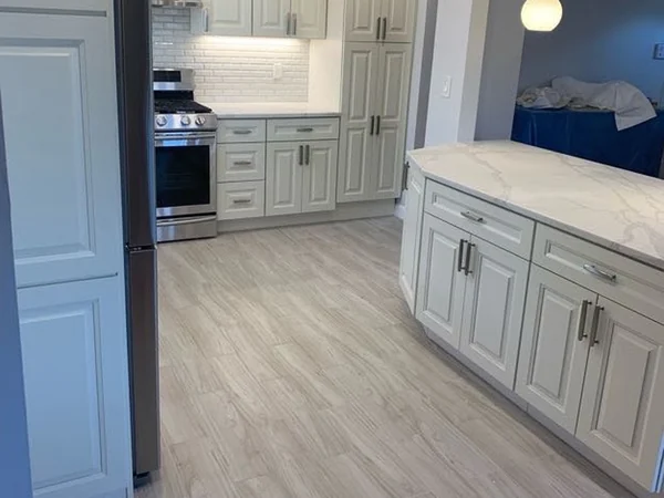 After: full-height pantry cabinet and wood-look porcelain plank flooring in the Whitestone kitchen