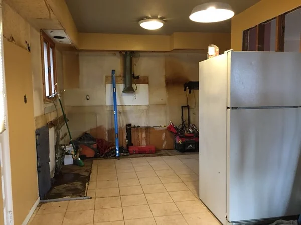 Demolition: cabinets and countertops removed, bare walls and exposed duct in the Whitestone kitchen